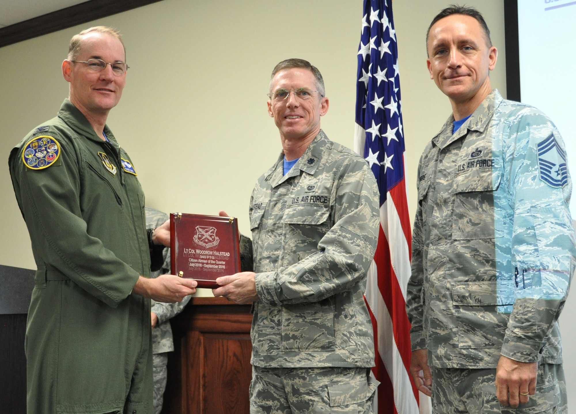 Col Roger Suro, 340th FTG commander (L),  and Chief Master Sgt. Jimmie Morris present Lt. Col. Woodrow Halstead (center) with the award for citizen airman of the quarter, third quarter during the Group's MUTA held Dec. 1-2 at Joint Base San Antonio-Randolph, Texas (Photo by Janis El Shabazz).