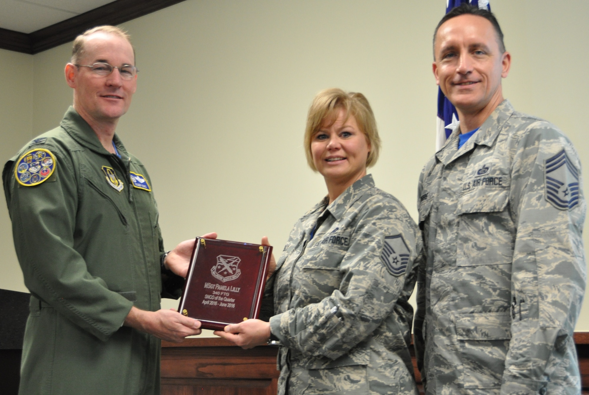 Master Sgt. Pamela Lilly receives a quarterly award for the 2nd quarter from Col. Roger Suro, 340th FTG commander (L) and group superintendent, Chief Master Sgt. Jimmie Morris during the Group's MUTA held Dec. 1-2 at Joint Base San Antonio-Randolph, Texas (Photo by Janis El Shabazz).