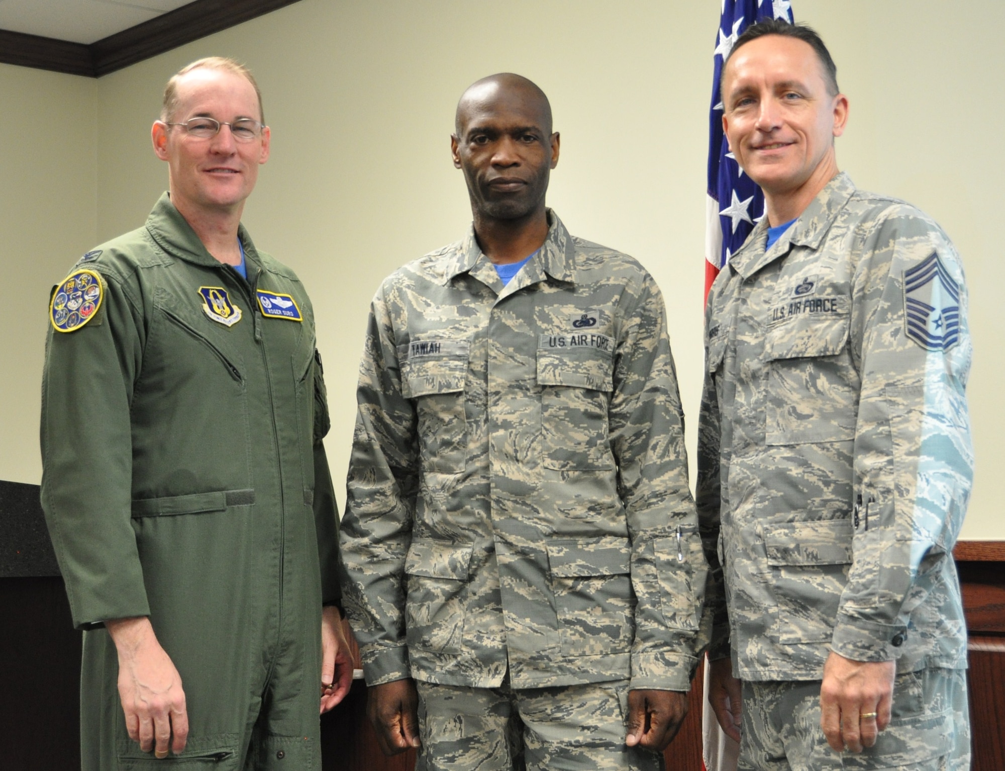 Senior Master Sgt. Kwame Tawiah stands with Col. Roger Suro, 340th FTG commander and group superintendent, Chief Master Sgt. Jimmie Morris during the group’s Dec. 1 MUTA at Joint Base San Antonio-Randolph, Texas  to recognize his selection as Humane Society Volunteer of the Month. (Photo by Janis El Shabazz).