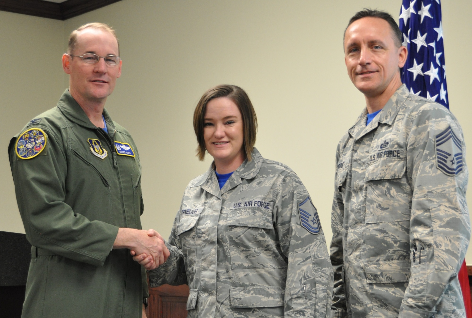 Master Sgt. Sarah Cornelius being coined by Col. Roger Suro, 340th FTG commander for her work with the Green Dot Program, as group superintendent, Chief Master Sgt. Jimmie Morris stands by to congratulate the member during the group’s Dec. 1 MUTA at Joint Base San Antonio-Randolph, Texas (Photo by Janis El Shabazz).