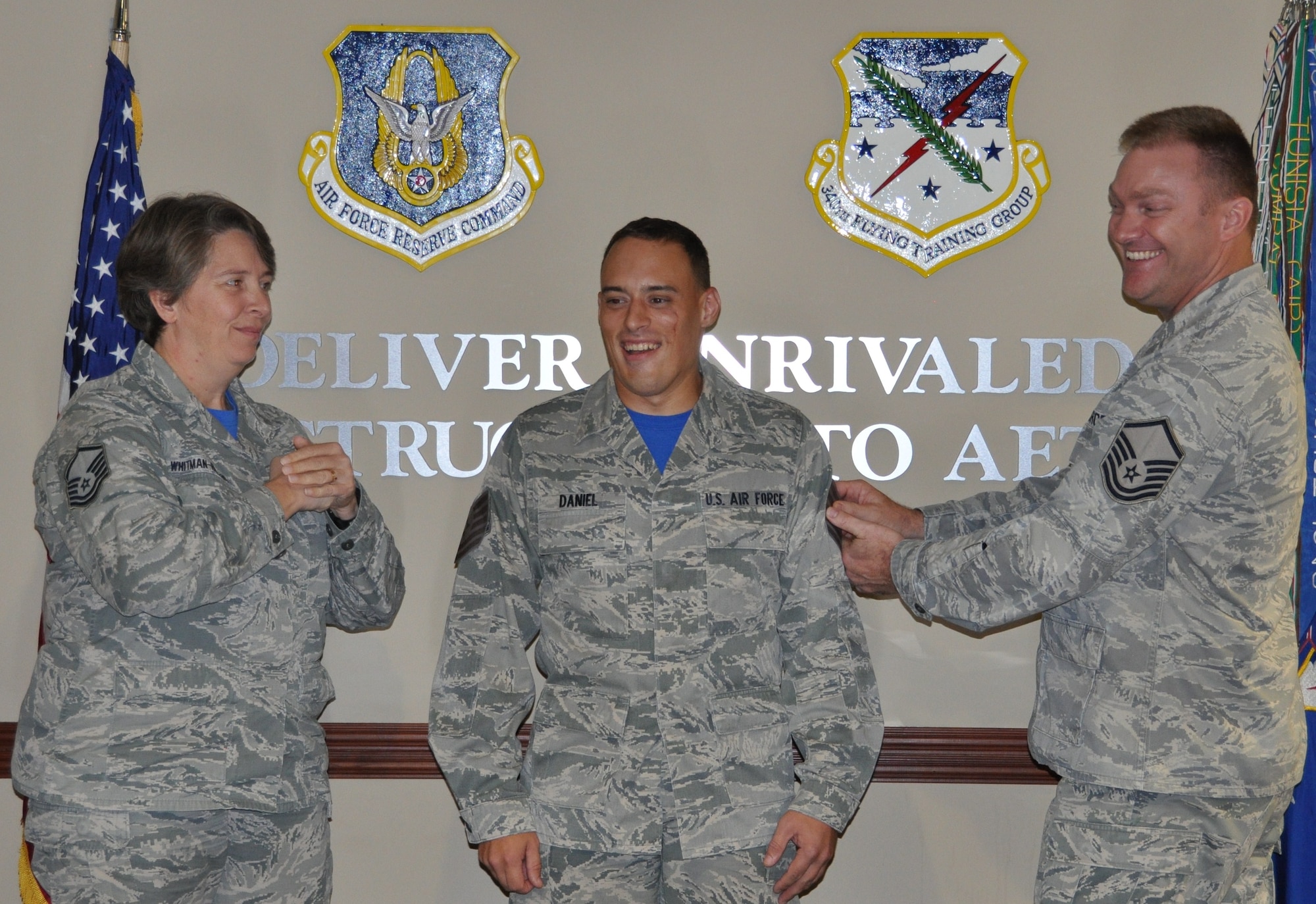 New Tech. Sgt. Brett Daniel gets his stripes tacked on by Master Sgt. Amy Whitman-Rector and his supervisor Master Sgt. Jason Daniels. at the Group's MUTA held Dec. 1-2 at Joint Base San Antonio-Randolph, Texas (Photo by Janis El Shabazz).