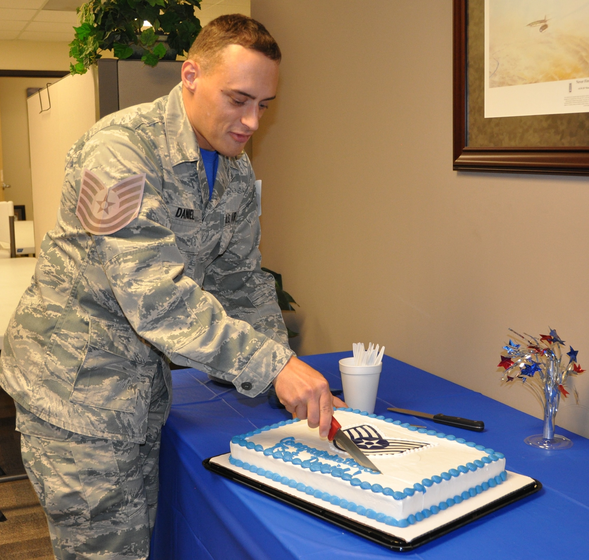 New Tech. Sgt. Brett Daniel serves up pieces of  cake at the celebration honoring his promotion during the Group's MUTA held Dec. 1-2 at Joint Base San Antonio-Randolph, Texas (Photo by Janis El Shabazz).

