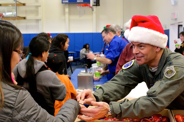 Commander of Alaskna Command, Lt. Gen. Kenneth Wilsbach, stamps an Akiachak child's hand before she receives ice cream during Operation Santa Claus, Dec. 3, 2016. This year marked the 60th anniversary in which the Alaska National Guard supported Operation Santa Claus with logistics and air support, delivering holiday cheer and gifts to remote Alaska villages. (U.S. Army National Guard photo by Capt. Amanda Plachek)