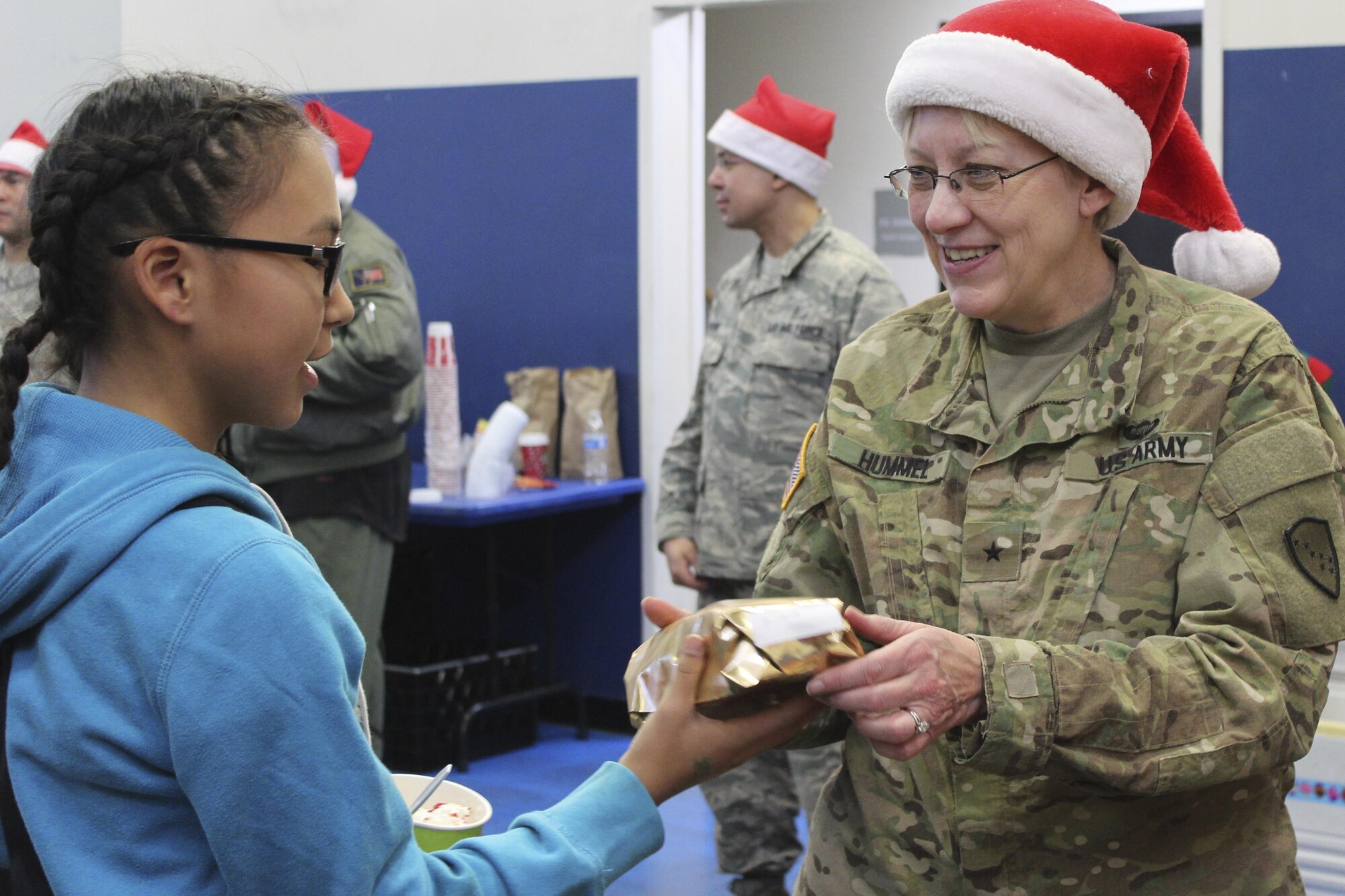Brig. Gen. Laurie Hummel, adjutant general for the Alaska National Guard, hands a gift to an Akiachak child during Operation Santa Claus, Dec. 3, 2016. This year marked the 60th anniversary in which the Alaska National Guard supported Operation Santa Claus with logistics and air support, delivering holiday cheer and gifts to remote Alaska villages. (U.S. Army National Guard photo by Capt. Amanda Plachek)