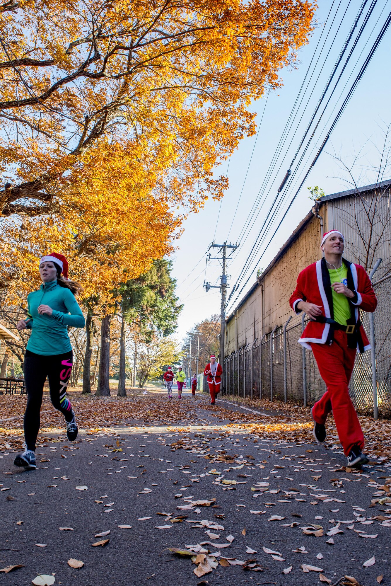 Participants run during the Santa Shuffle 5K Fun Run Dec. 10, 2016, at Yokota Air Base, Japan. The event consisted of over 50 participants who were provided with Santa hats and outfits from the Yokota Striders. (U.S. Air Force photo by Airman 1st Class Donald Hudson/Released)