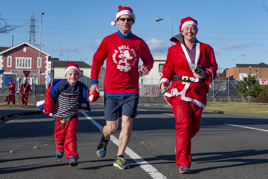 Participants cross the finish line together during the Santa Shuffle 5K Fun Run Dec. 10, 2016, at Yokota Air Base, Japan. The event was the first time the Yokota Striders organized the holiday themed fun run and provided Santa hats and outfits for participants. (U.S. Air Force photo by Airman 1st Class Donald Hudson/Released)