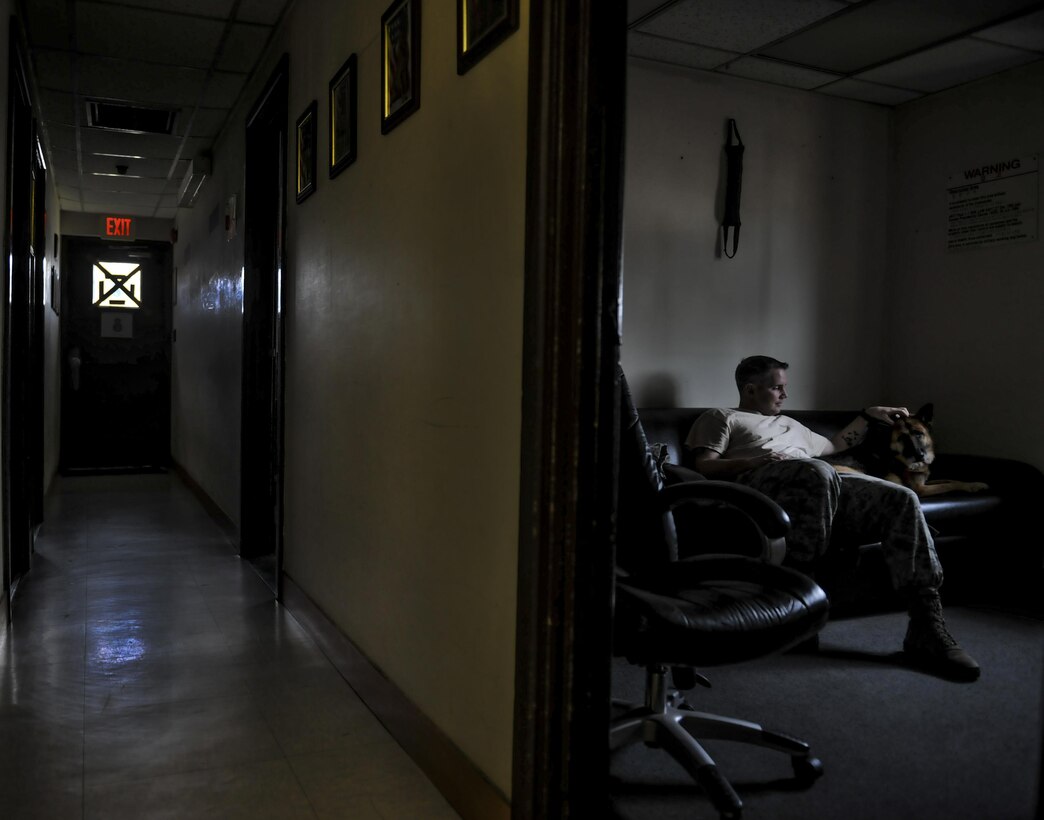 Staff Sgt. Bryan Tarantella, 8th Security Forces Squadron military working dog handler, scratches the head of Stella, 8th Security Forces Squadron military working dog, inside the MWD compound at Kunsan Air Base, Republic of Korea, Nov. 11, 2016. Stella has come to the end of her military service and will be retiring because of lumbosacral disease, which is the degeneration of the joints, spine and compression of the nerves causing lower back discomfort as well as leg pain. Tarantella plans to adopt Stella after her retirement. (U.S. Air Force photo by Senior Airman Colville McFee/Released)