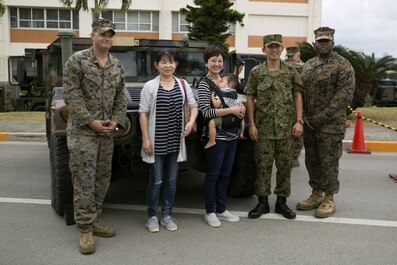 A family poses with Marines and a Japan Ground Self Defense Force service member next to a Humvee Nov. 20, 2016 during the JGSDF Festival on Camp Naha, Okinawa, Japan. The festival celebrated the 6th anniversary of the 15th brigade and the 44th anniversary of Camp Naha. Marines with Combat Assault Battalion, 3rd Marine Division, III Marine Expeditionary Force brought the Humvee, a Light Armored Vehicle and an Assault Amphibious Vehicle for display. Attendees of the festival were able to take photos with the Marines and their vehicles. (U.S. Marine Corps photo by Cpl. Jessica Collins) 