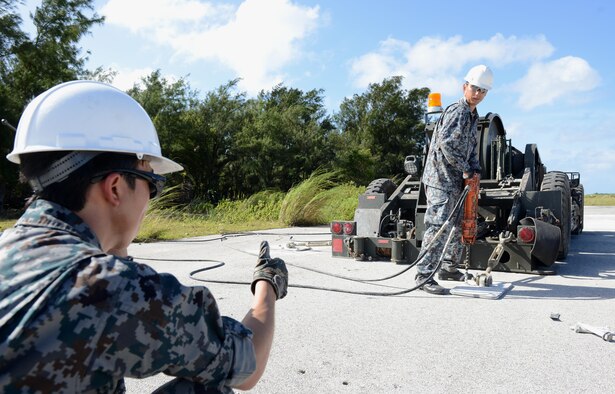 Airmen with the Japan Air Self-Defense Force conduct Mobile Aircraft Arresting System installation training Dec. 6, 2016, at Northwest Field, Guam. A MAAS is a rapid installation emergency system used to recover fighter aircraft returning to and launching from a battle damaged airfield. (U.S. Air Force photo by Senior Airman Arielle K. Vasquez/Released)