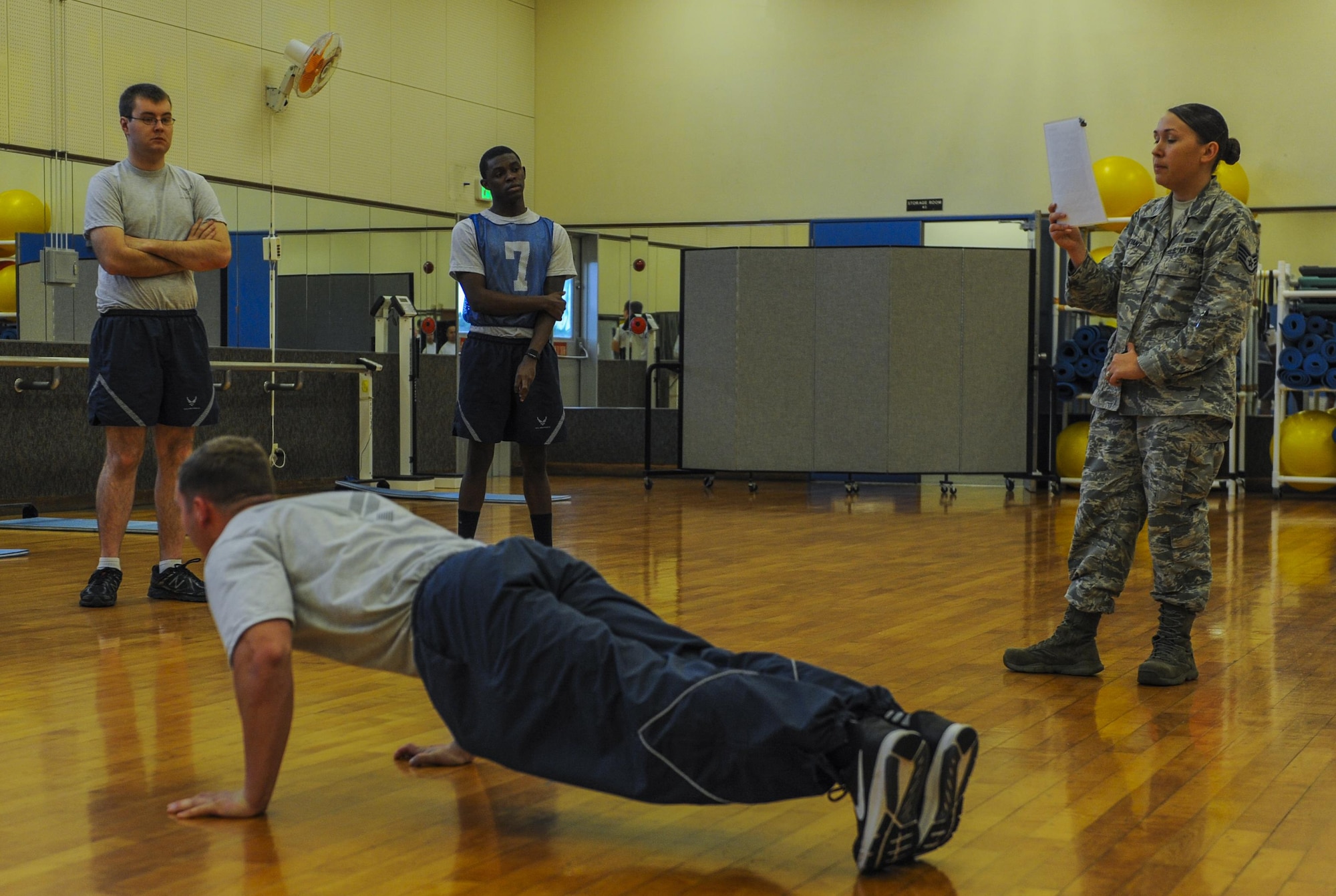 U.S. Air Force Senior Airman Robert Prouty, 18th Equipment Maintenance Squadron crew chief and physical training leader, demonstrates proper form for physical fitness testing, Dec. 1, 2016, at the Risner Fitness Center on Kadena Air Base, Japan. Beyond testing, PTLs help Airmen improve in trouble areas to ensure fitness priorities across the Air Force. (U.S. Air Force photo by Airman 1st Class Nick Emerick/Released)