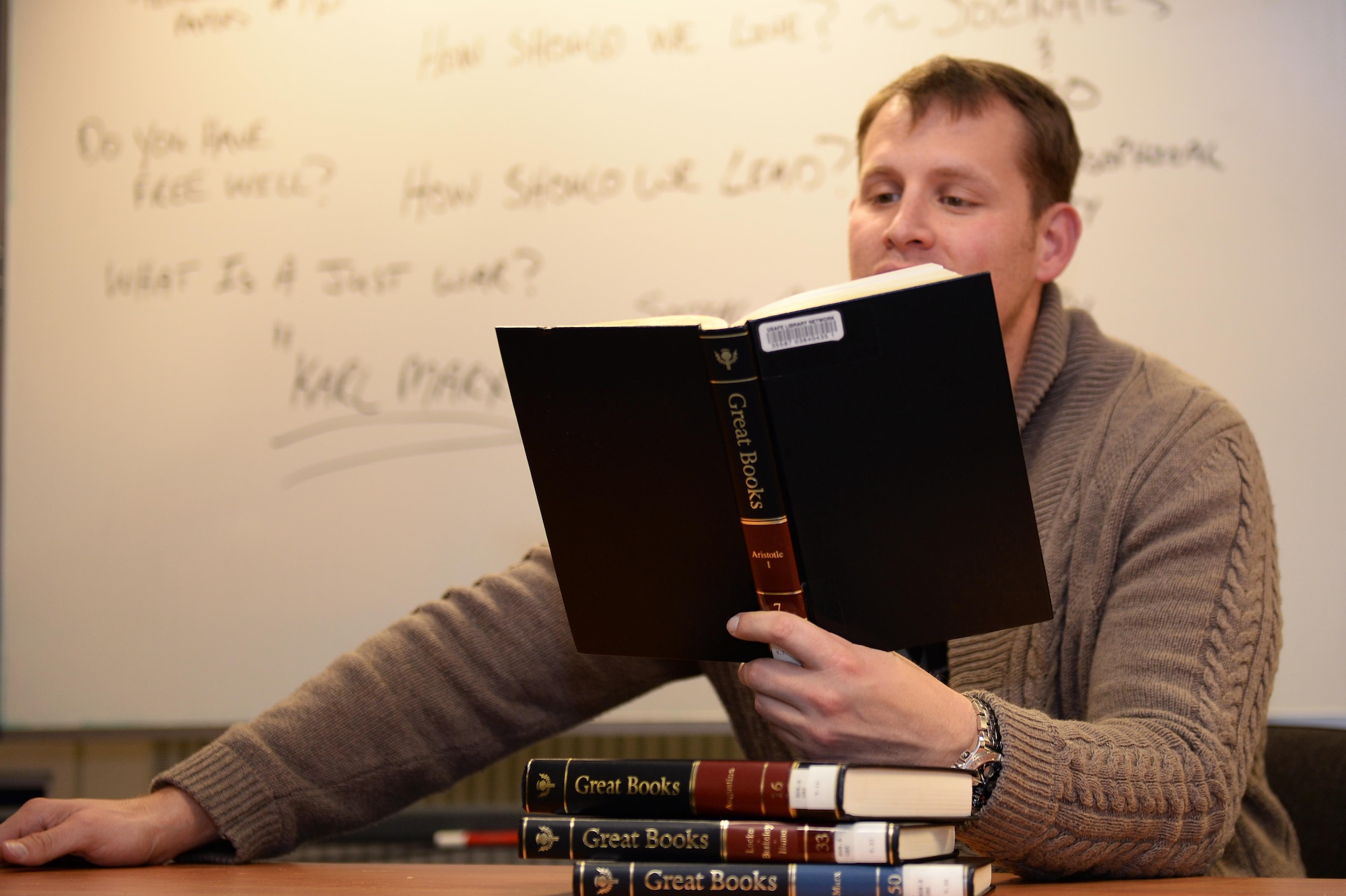 The Lakenheath Philosophical Society president reads a passage about Socrates and his views during a meeting at Royal Air Force Lakenheath, England, Dec. 5. The society meets monthly, and discusses an array of philosophical questions that have been around for centuries. (U.S. Air Force photo/ Staff Sgt. Emerson Nunez)