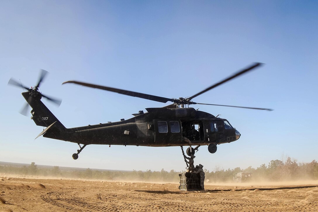 Soldiers secure an A22 cargo bag to an UH-60 Black Hawk helicopter during slingload training at Fort Bragg, N.C., Dec. 7, 2016. Army photo by Sgt. Steven Galimore