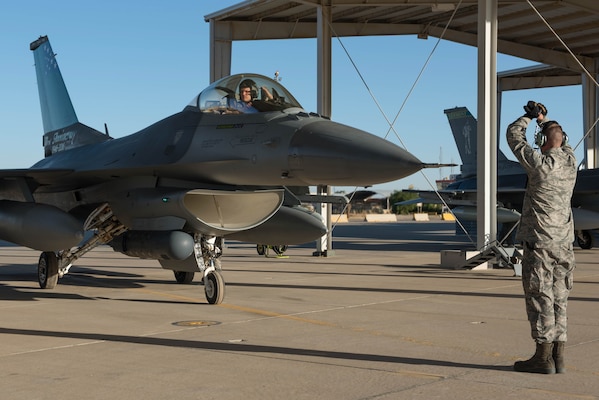 An crew chief with the 407th Expeditionary Aircraft Maintenance Squadron marshals an F-16 Fighting Falcon pilot with the 134th Expeditionary Fighter Squadron onto the ramp after arriving at the 407th Air Expeditionary Group, Southwest Asia, Dec. 10, 2016. About 300 Airmen from the 158th Fighter Wing of the Vermont Air National Guard arrived in the past few days to support the F-16 mission here. (U.S. Air Force photo by Master Sgt. Benjamin Wilson)(Released)