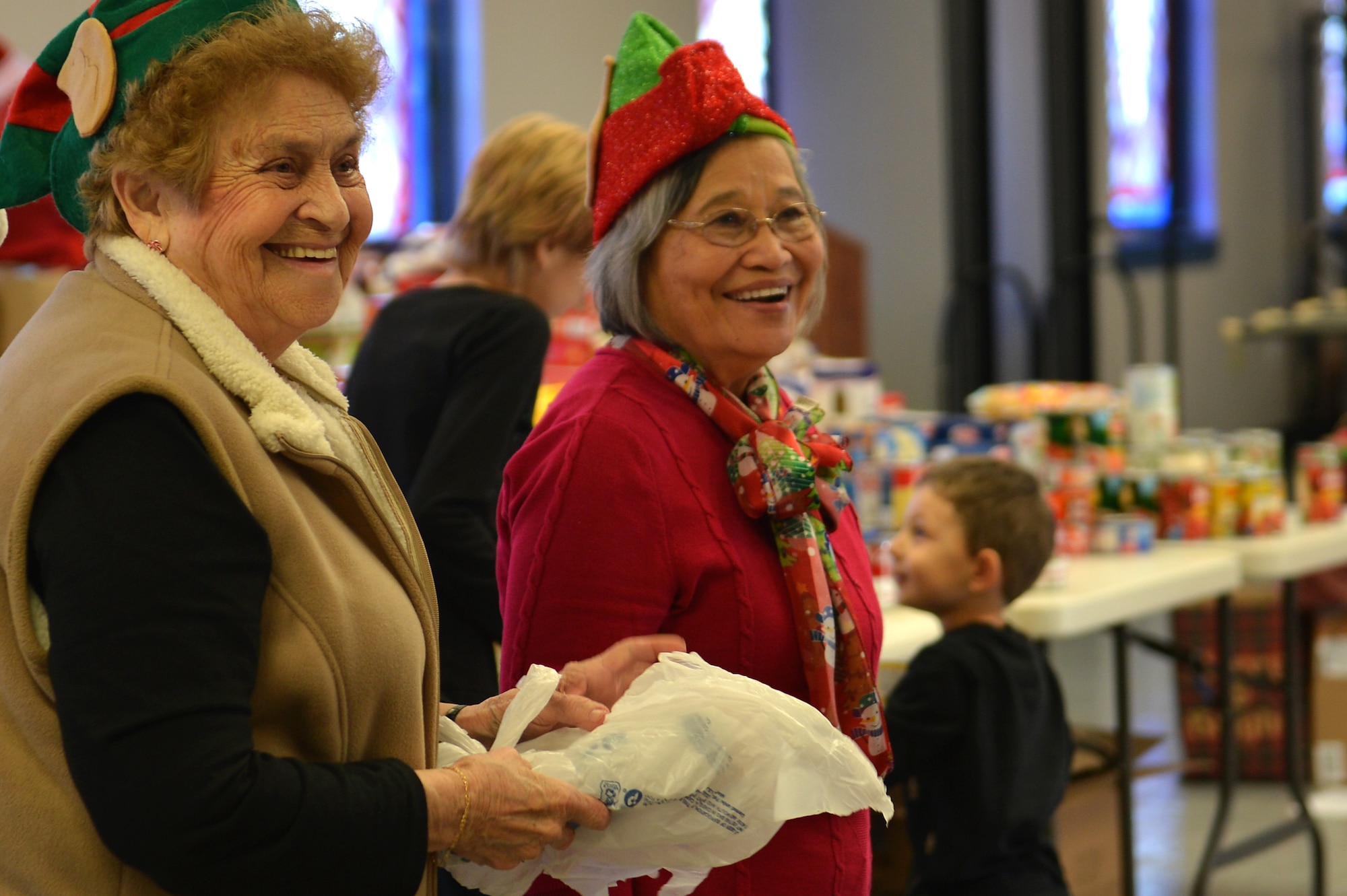 Stella Bailey, left, and Polly Depra, right, Operation True Giving committee members, take a break from organizing during an Operation True Giving food and gift drive at the Palmetto Chapel on Shaw Air Force Base, S.C., Dec. 9, 2016. Throughout the drive, volunteers and committee members donated presents to include clothing, canned foods and toys. (U.S. Air Force photo by Airman 1st Class Christopher Maldonado)