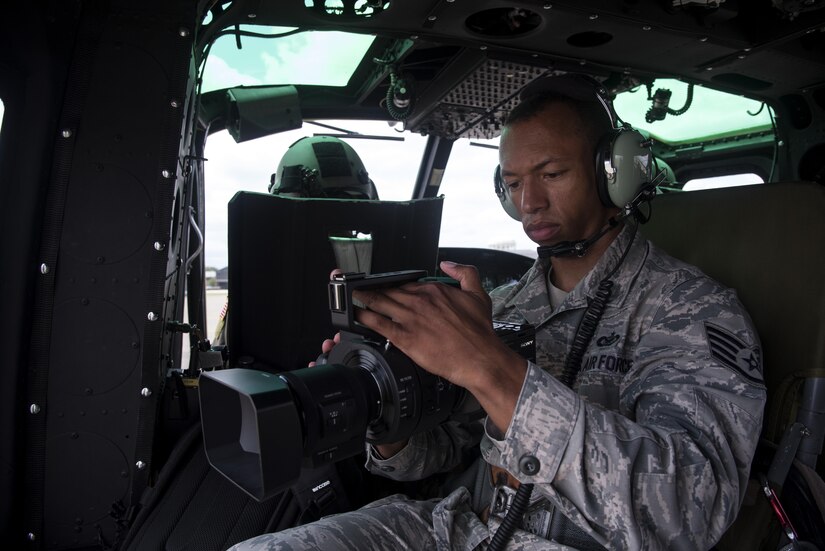 Staff Sgt. Jason Shamberger, 11th Wing Public Affairs broadcaster, takes video inside a UH-1N Huey at Joint Base Andrews, Md., Aug. 3, 2016. Shamberger takes video used for the Air Force District of Washington mission video put together by the 11 WG PA office. (U.S. Air Force photo by Senior Airman Philip Bryant)