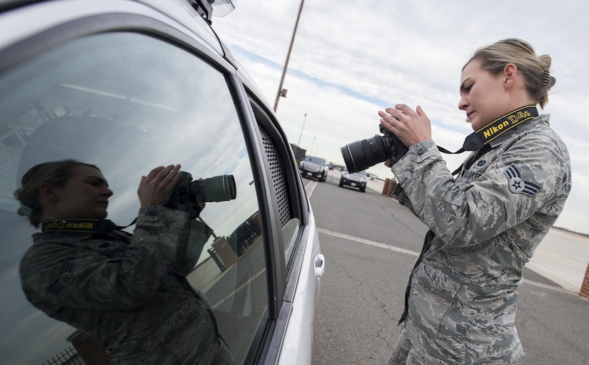 Senior Airman Mariah Haddenham, 11th Wing Public Affairs photojournalist, takes a photo of a military working dog inside a security forces vehicle at Joint Base Andrews, Md., Dec. 8, 2016. Haddenham used the photos in a story emphasizing the importance of MWDs and their role on the flightline. (U.S. Air Force photo by Senior Airman Philip Bryant)