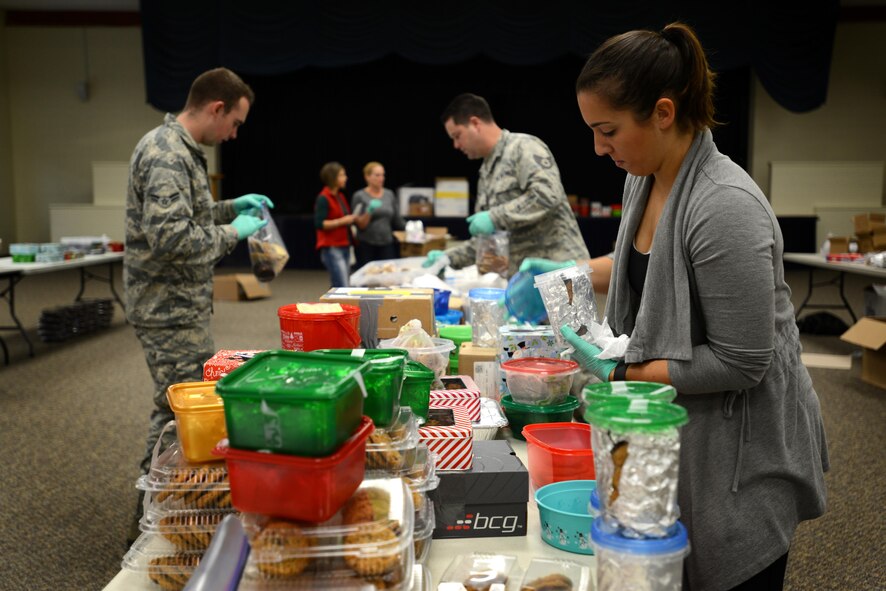 U.S. Air Force Senior Airman Diana Cossaboom, 20th Fighter Wing Public Affairs photojournalist, unpacks cookies during the annual cookie drive at Shaw Air Force Base, S.C., Dec. 8, 2016. The cookie drive was run by 58 volunteers over two days, sorting and packing 46,224 cookies to be sent to deployed service members, and delivered to Airmen and Soldiers living in the dorms on Shaw AFB, Fort Jackson, S.C., community outreach shelters, and the local chapter of the YWCA. (U.S. Air Force photo by Airman 1st Class Kelsey Tucker)