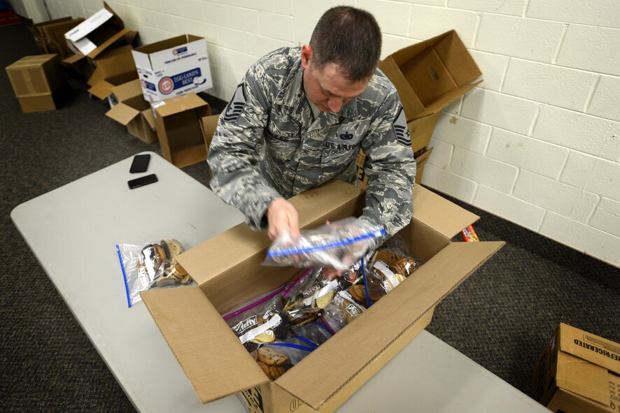 U.S. Air Force Master Sgt. Wesley Skiles, 20th Logistics Readiness Squadron superintendent, packs bags of cookies into boxes for distribution during the annual cookie drive at Shaw Air Force Base, S.C., Dec. 8, 2016. This year marked the 23rd year Team Shaw held the cookie drive, which brought in nearly 4,000 dozen cookies for service members at home and deployed during the holidays. (U.S. Air Force photo by Airman 1st Class Kelsey Tucker)