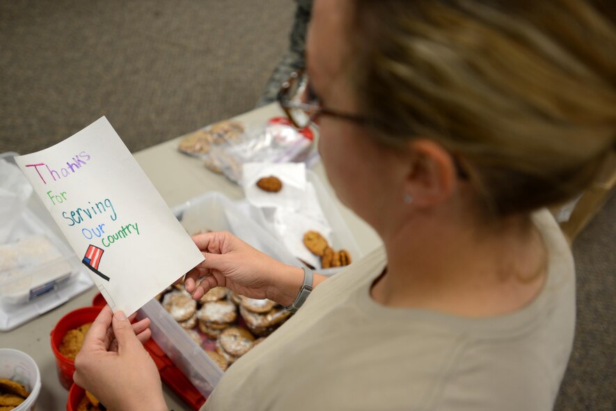 A U.S. Airman reads a card during the annual cookie drive at Shaw Air Force Base, S.C., Dec. 8, 2016. Nearly 5,100 cards were donated by members of the Greater Sumter community alongside 3,852 dozen cookies, which were then sent to deployed Team Shaw members, overseas chaplains, and patients at Walter Reed Army Medical Center, Washington, D.C. (U.S. Air Force photo by Airman 1st Class Kelsey Tucker)