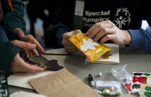 Tech. Sgt. Antonio Couto, 450th Intelligence Squadron all-source analyst, helps Marcel, a Winter Special Olympics participant, with arts and crafts at Vogelweh Military Complex, Germany, Dec. 2, 2016. On the first Friday of December, the 450th IS Airmen volunteered throughout the Kaiserslautern Military Community as their way to give back to the community. (U.S. Air Force photo by Senior Airman Tryphena Mayhugh)