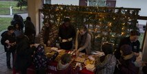 Several Airmen assigned to the 450th Intelligence Squadron pass out cookies at the Fisher House’s tree-lighting ceremony at Landstuhl Regional Medical Center, Germany, Dec. 2, 2016. On the first Friday of December, the 450th IS volunteered throughout the community for their annual service day. (U.S. Air Force photo by Senior Airman Tryphena Mayhugh)