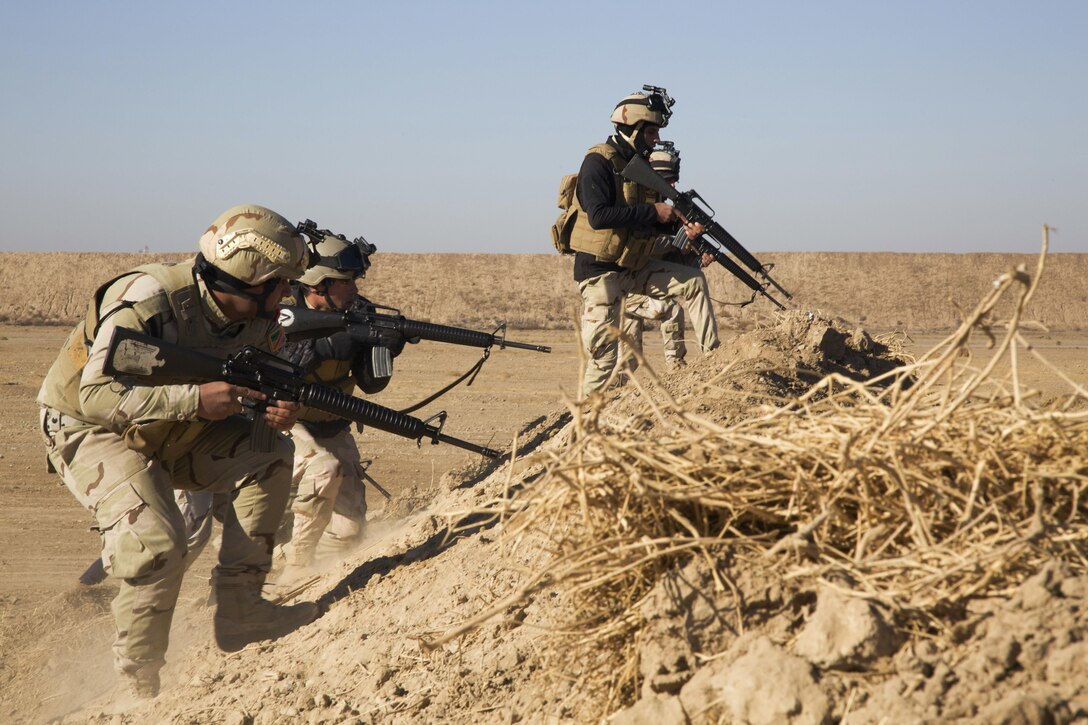 Iraqi soldiers attending the Iraqi Noncommissioned Officer Academy climb over a berm during live fire open terrain maneuver training at Camp Taji, Iraq, Dec. 10, 2016. This training is critical to enabling Iraqi security forces to counter ISIL and regain territory from the terrorist group. Combined Joint Task Force - Operation Inherent Resolve is the global Coalition to defeat ISIL in Iraqi and Syria. (U.S. Army photo by Spc. Craig Jensen)