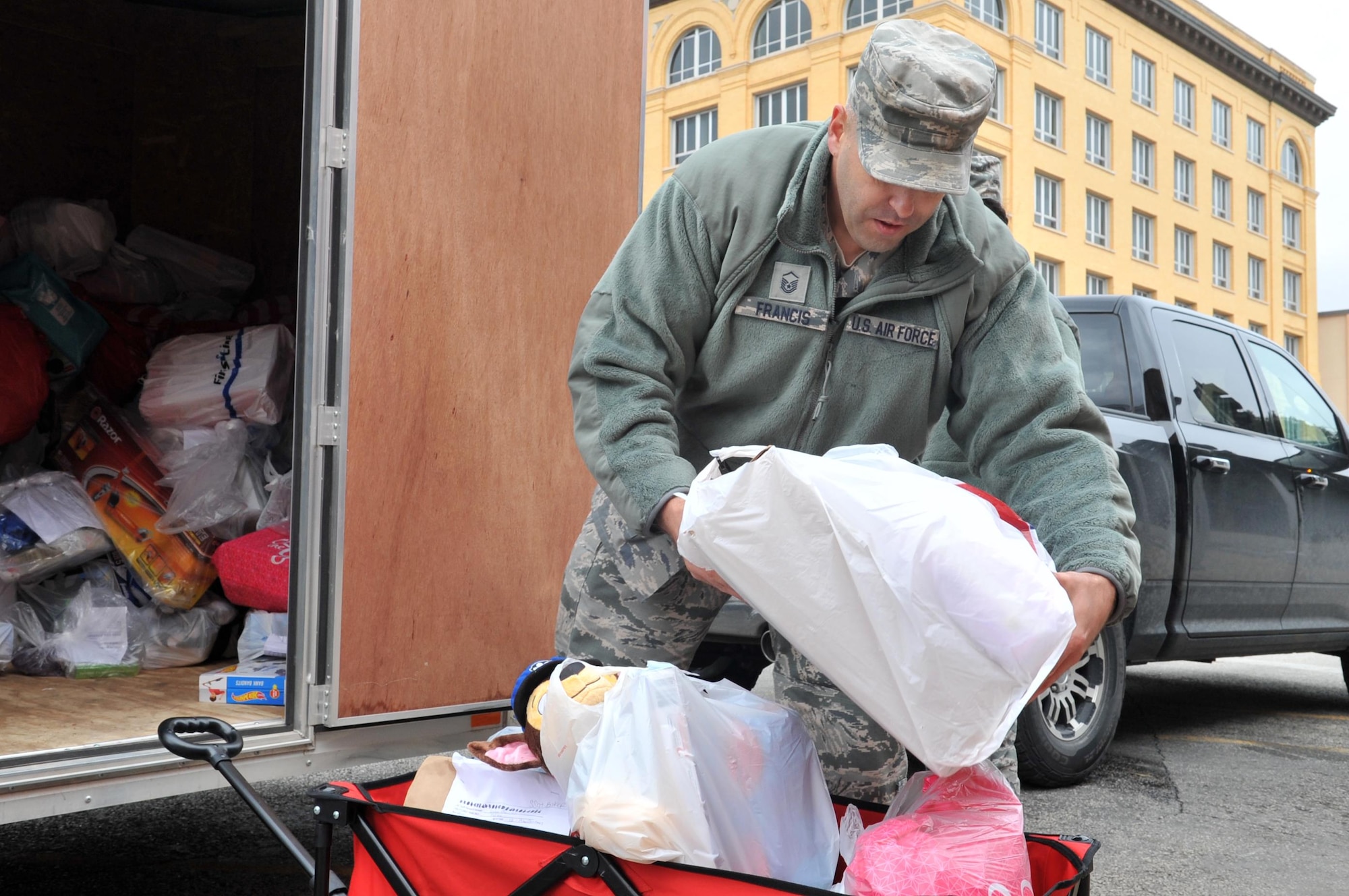 U.S. Air Force Master Sgt. Christopher Francis, 17th Contracting Squadron superintendent, loads toys into a wagon during delivery to the Court Appointed Special Advocates for Children center in San Angelo, Texas, Dec. 8, 2016. The toys are for children in emergency foster care. (U.S. Air Force photo by Staff Sgt. Laura R. McFarlane/Released)