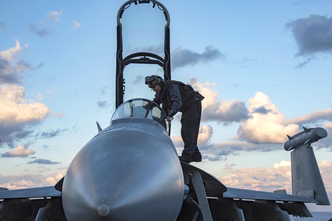 Navy Petty Officer 3rd Class Landon McCullough adjusts a control panel in the cockpit of an EA-18G Growler on the flight deck of the aircraft carrier USS Dwight D. Eisenhower in the Mediterranean Sea, Dec. 8, 2016. Navy photo by Petty Officer 3rd Class Robert J. Baldock