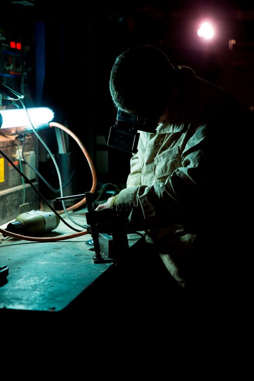 U.S. Marine Lance Cpl. James Sonzogni, a welder with Heavy Equipment Platoon, 1st Maintenance Battalion, 1st Marine Logistics Group, grinds a piece of metal to prepare it for welding during exercise Steel Knight at Marine Corps Air Ground Combat Center Twentynine Palms, Calif., Dec. 8, 2016. Steel Knight 2017 is a 1st Marine Division-led exercise that exposes Marines and Sailors to skill sets necessary to operate as a fully capable Marine air ground task force. Sonzogni is from North Clifton, N.J. (U.S. Marine Corps photo by Sgt. Abbey Perria)