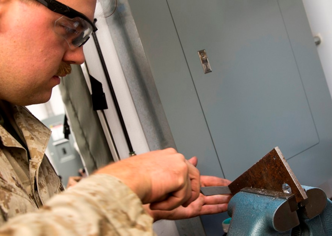 .S. Marine Cpl. Benjamin Smith, a machinist with Engineer Maintenance Company, 1st Maintenance Battalion, 1st Marine Logistics Group, files a piece of metal during exercise Steel Knight at Marine Corps Air Ground Combat Center Twentynine Palms Dec. 8, 2016. Steel Knight 2017 is a 1st Marine Division-led exercise that exposes Marines and Sailors to skill sets necessary to operate as a fully capable Marine air ground task force. Smith is from Milford, N.H. (U.S. Marine Corps photo by PFC Timothy Shoemaker)
