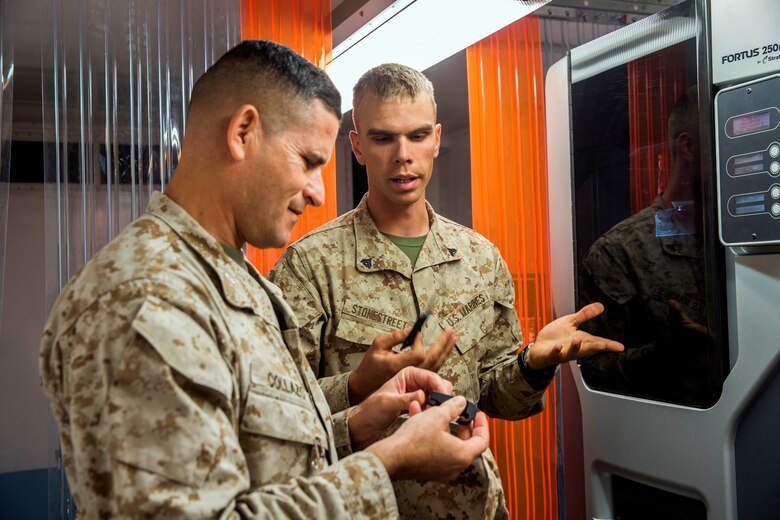 U.S. Marine Cpl. Samuel Stonestreet, a ground radio repairman with 1st Maintenance Battalion, 1st Marine Logistics Group, tells Col. Jaime Collazo, the commanding officer of Combat Logistics Regiment 15, 1st MLG, about an item 1st Maintenance Bn. made with the Expeditionary Manufacturing Facility during the Steel Knight 2017 exercise at Marine Air Ground Combat Center Twentynine Palms, Calif., Dec. 8, 2016. Steel Knight 2017 is a 1st Marine Division-led exercise that exposes Marines and Sailors to skill sets necessary to operate as a fully capable Marine air ground task force. (U.S. Marine Corps photo by Lance Cpl. Adam Dublinske)