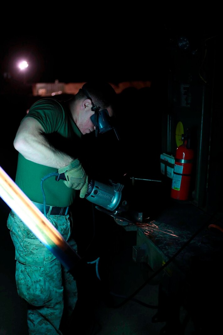 U.S. Marine Lance Cpl. James Sonzogni, a welder with Heavy Equipment Platoon, 1st Maintenance Battalion, 1st Marine Logistics Group, grinds a piece of metal to prepare it for welding during exercise Steel Knight at Marine Corps Air Ground Combat Center Twentynine Palms, Calif., Dec. 8, 2016. Steel Knight 2017 is a 1st Marine Division-led exercise that exposes Marines and Sailors to skill sets necessary to operate as a fully capable Marine air ground task force. Sonzogni is from North Clifton, N.J. (U.S. Marine Corps photo by PFC Timothy Shoemaker)