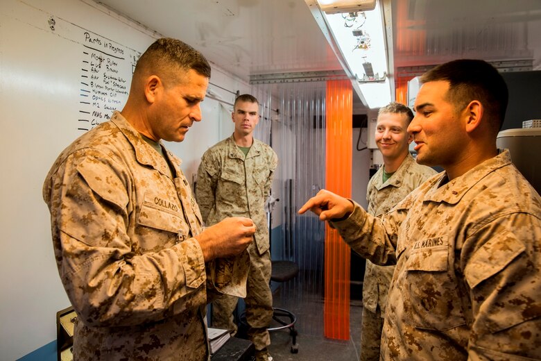 U.S. Marine Chief Warrant Officer 2 Sean Smith, the ground communications officer for Reparable Maintenance Company, 1st Maintenance Battalion, 1st Marine Logistics Group, tells Col. Jaime Collazo, the commanding officer of Combat Logistics Regiment 15, 1st MLG, about an item 1st Maintenance Bn. made with the Expeditionary Manufacturing Facility during exercise Steel Knight 2017 at Marine Air Ground Combat Center Twentynine Palms, Calif., Dec. 8, 2016. Steel Knight 2017 is a 1st Marine Division-led exercise that exposes Marines and Sailors to skill sets necessary to operate as a fully capable Marine air ground task force. (U.S. Marine Corps photo by Lance Cpl. Adam Dublinske)