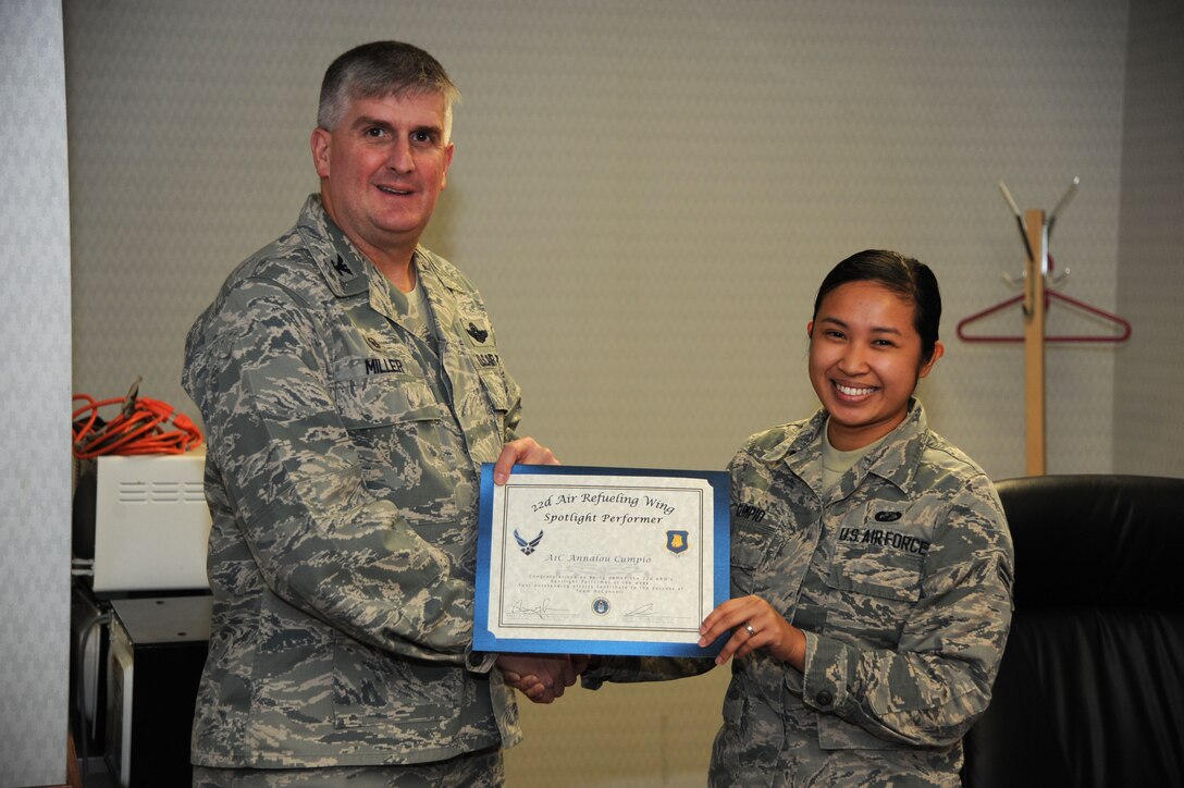 Airman 1st Class Annalou Cumpio, 22nd Comptroller Squadron customer service technician, poses with Col. Albert Miller, 22nd Air Refueling Wing commander, Dec. 1, 2016, at McConnell Air Force Base, Kan. Cumpio received the spotlight performer for the week of Oct. 31- Nov. 4. (U.S. Air Force photo/Airman 1st Class Jenna K. Caldwell)