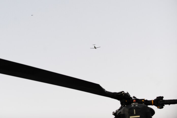 A U-28 assigned to the U.S. Air Force Weapons School’s 14th Weapons Squadron flies enroute to the Delmar desert landing zone, Nev., Dec. 2.  A U.S. Army MH-47, (blades, foreground) assigned to 160th Special Operations Aviation Regiment awaits at forward area refueling point, while a 14th WPS, AC-130U provides close air support.  The 14th WPS hosted 17 diverse units and other government agencies during a hostage rescue exercise, as part of the USAF Weapons School Integration phase.