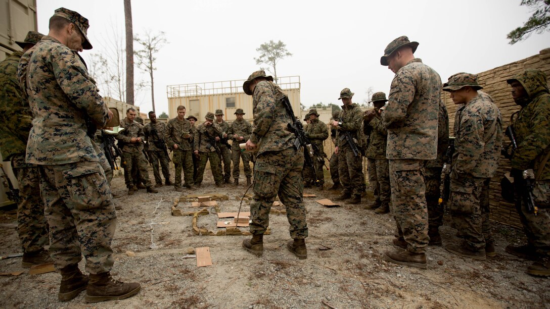 Marines get briefed using a terrain model of a Military Operations Urban Terrain course at Marine Corps Base Camp Lejeune, N.C., Dec. 8th, 2016. MOUT is a combat course that allows Marines to train in an urban environment in which they secure buildings while taking simulated enemy fire. These Marines are with 2nd Battalion, 2nd Marine Regiment, 2nd Marine Division.