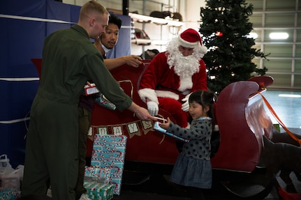 U.S. Marine Corps Lance Cpl. Jeffery Deal, aircraft rescue and firefighting (ARFF) specialist, passes a candy cane to May Yamane, a child with the local orphanage, during the ARFF Tsuta Orphanage Christmas party at Marine Corps Air Station Iwakuni, Dec. 10, 2016.  ARFF holds the celebration annually to help spread holiday cheer to the orphans and to bring service members, their families and Japanese together. Marines volunteered their time and provided the children with a homemade, American meal. After dinner, a special guest came to greet the children. Santa Claus sat in a red sleigh passing out presents and candy canes to the kids. Marines were given the name, age and gender of a child from the orphanage, so they knew what kind of gift to buy for them. 