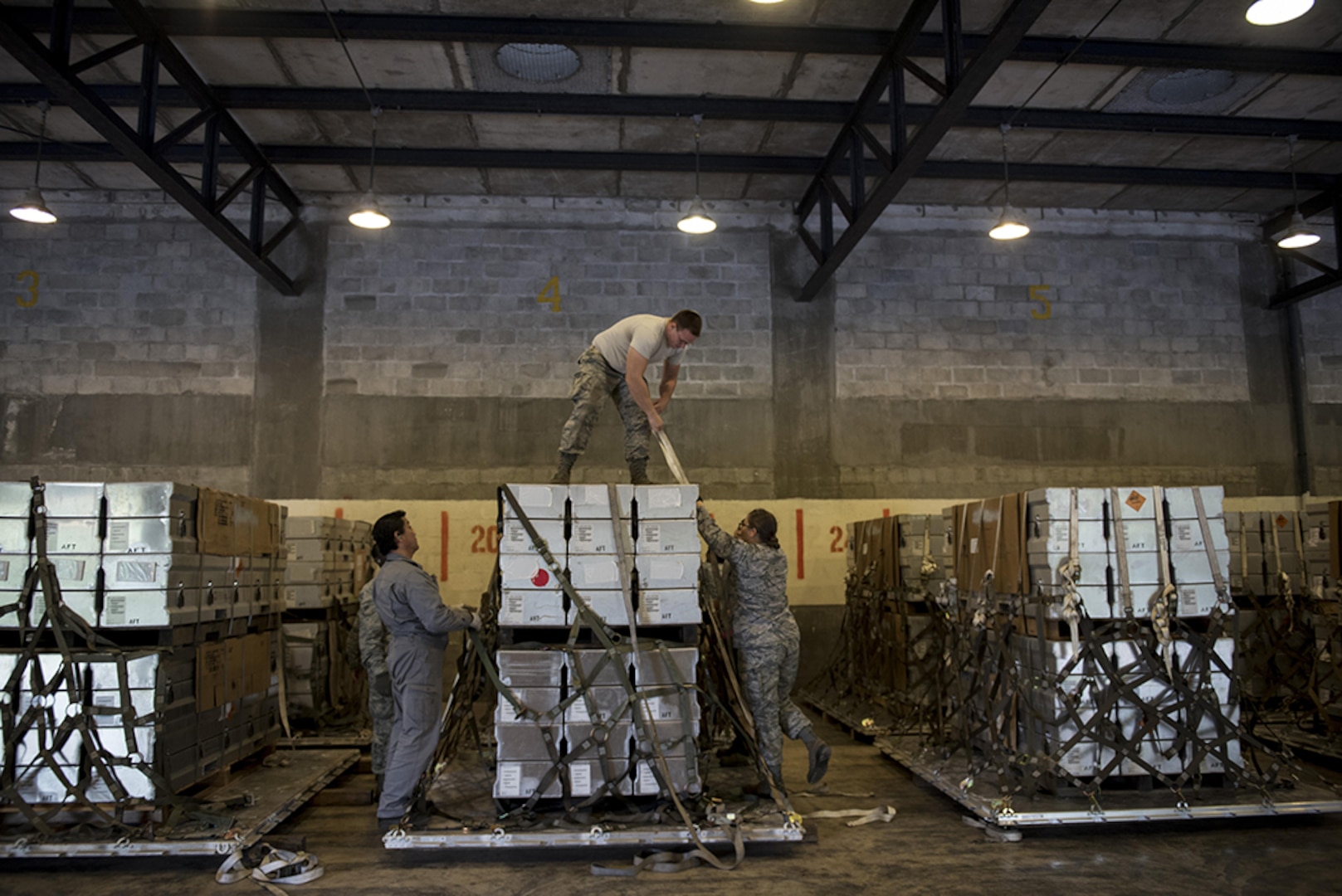 U.S. Air Force Airmen tie down and secure munitions to pallets during a Tactical Ammunition Rapid Response Package exercise Dec. 6, 2016, at Kadena Air Base, Japan. The TARRP exercise simulates how the squadron would rapidly prepare munition packages for transport downrange in times of war. 