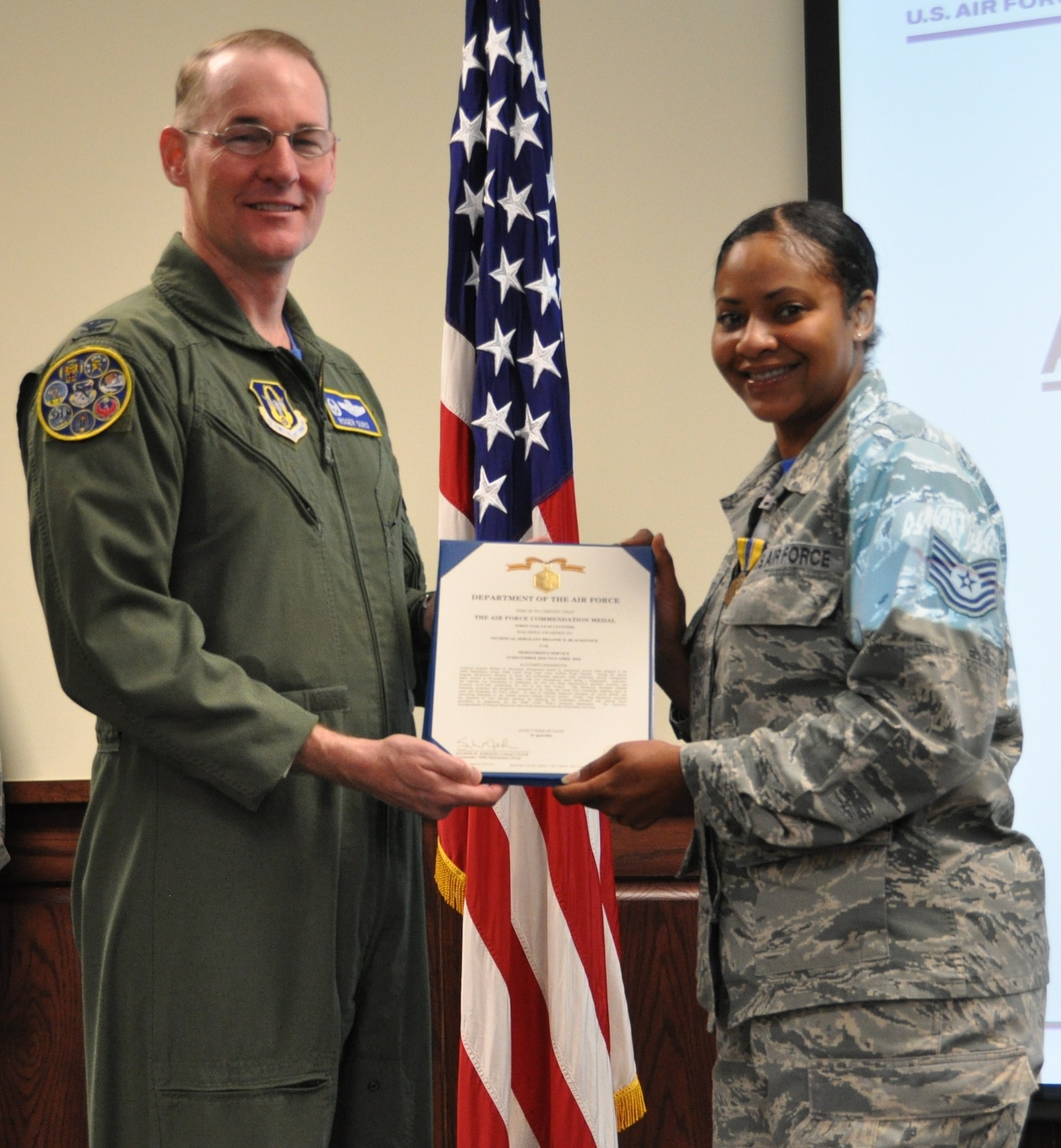 Tech. Sgt. Brianne Blackstock receives an Air Force Commendation Medal from 340th FTG commander, Col. Roger Suro  at the Group's MUTA held Dec. 1-2 at Joint Base San Antonio-Randolph, Texas (Photo by Janis El Shabazz).