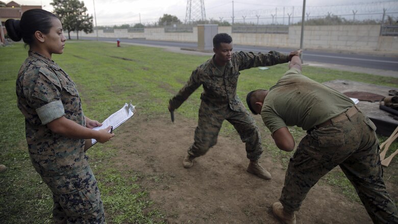 Sgt. Angie Novoa, a warehouse chief with Special Purpose Marine Air-Ground Task Force Crisis Response-Africa, watches a Marine execute a Marine Corps Martial Arts Program technique during a brown belt course test on Naval Air Station Sigonella, Italy, Oct. 13, 2016.  Novoa was awarded the non-commissioned officer of the quarter for her exemplary work in and out of the supply shop while deployed with SPMAGTF-CR-AF. 