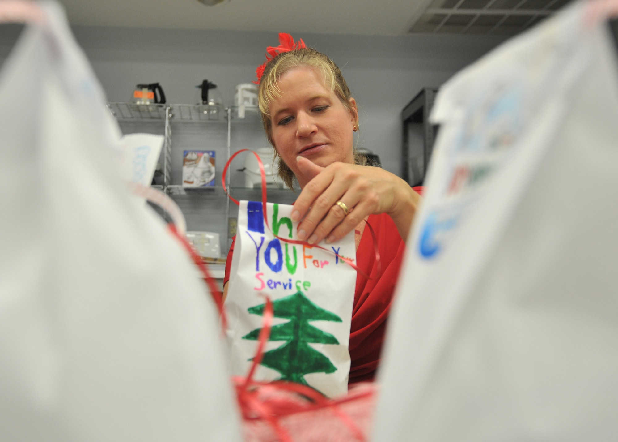 Katie George, Tyndall Spouses Club member, prepares a cookie bag for the Cookie Caper event at the thrift shop on Tyndall Air Force Base, Fla., Dec. 12, 2016. The Cookie Caper allowed volunteers to spread holiday cheer to residents of the base dormitories in the form of baked goods. Approximately382 Airmen can expect to receive cookies during the 2016 Cookie Caper. (U.S. Air Force photo by Senior Airman Ty-Rico Lea/Released)