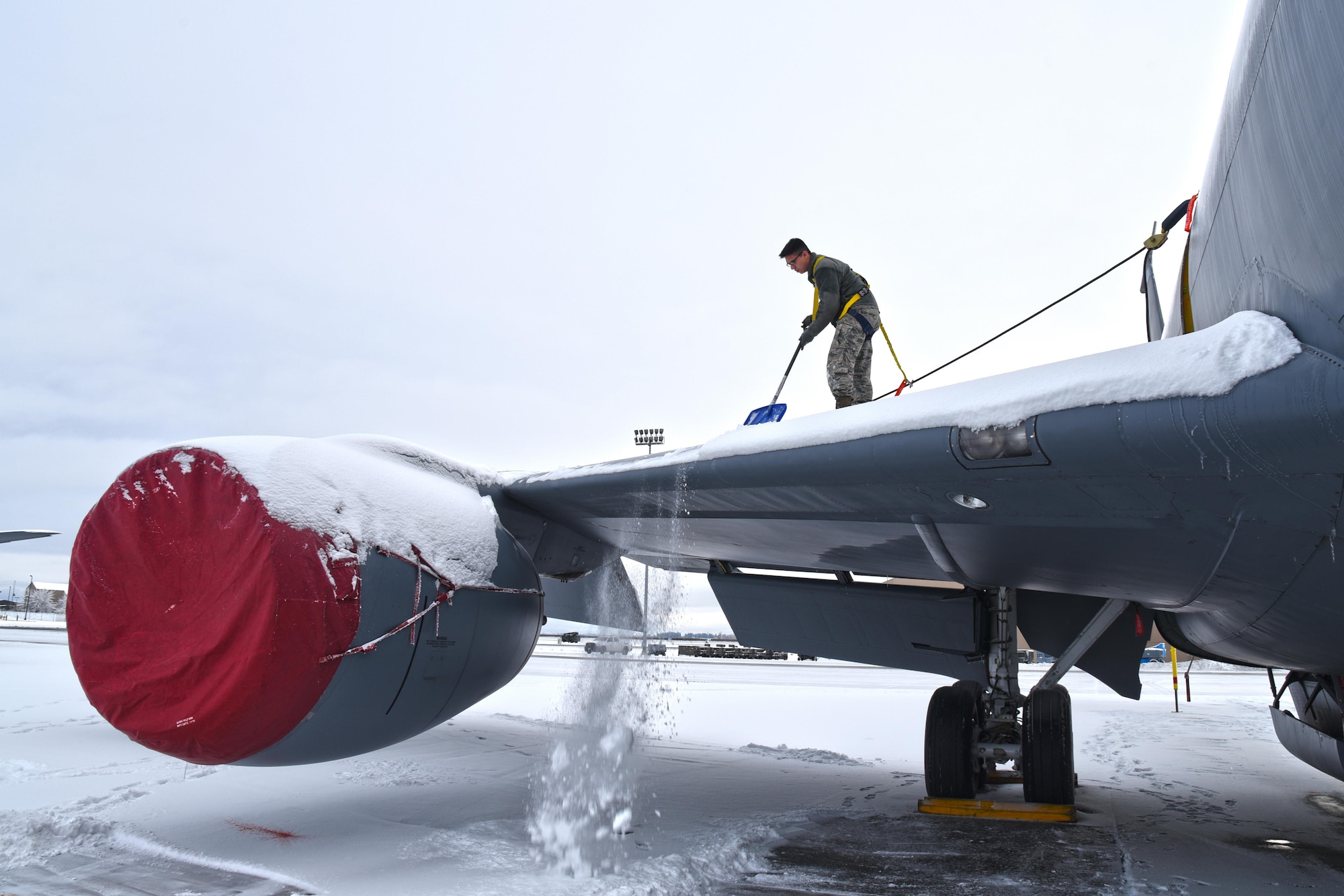 Airman Jesus Hilario, 92nd Aircraft Maintenance Squadron crew chief, manually deices a KC-135 Stratotanker by shoveling snow off of the wing Dec. 12, 2016, at Fairchild Air Force Base, Washington. During the winter months, Airmen remove the snow sitting on and around the aircraft using shovels and ropes. (U.S. Air Force photo/Senior Airman Mackenzie Richardson)