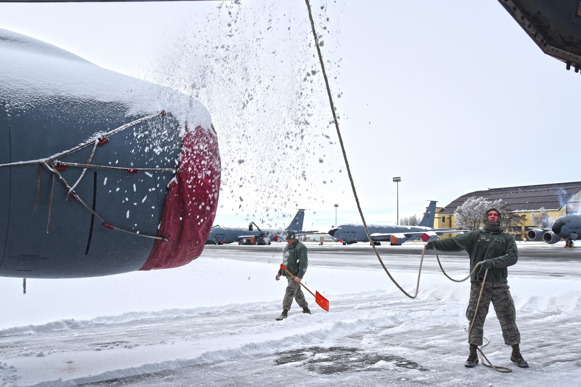 Senior Airman Benjamin Bennett, 92nd Aircraft Maintenance Squadron crew chief, manually deices a KC-135 Stratotanker using a rope Dec. 12, 2016, at Fairchild Air Force Base, Washington. By moving a rope over hard to reach areas of the jet, including the fuselage and wings, Airmen can successfully remove the heavy sheets of snow before applying deicing fluid. (U.S. Air Force photo/Senior Airman Mackenzie Richardson)