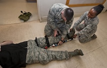 (From left) Senior Airman Robert Moon, 5th Medical Operations Squadron aerospace medical technician, and Staff Sgt. Afsatu Kamara, 5 MDOS emergency medical technician, connect a traction splint to a simulated patient at Minot Air Force Base, N.D., Dec. 1, 2016. Ambulance services Airmen use traction splints to reduce pain, realign limbs and minimize a patient’s vascular and neurological complications. (U.S. Air Force photo/Airman 1st Class Jonathan McElderry)