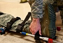 An Airman with the 5th Medical Operations Squadron applies tension on a simulated broken leg at Minot Air Force Base, N.D., Dec. 1, 2016. The ambulance services department here responds to all 911 emergency calls for Team Minot.  (U.S. Air Force photo/Airman 1st Class Jonathan McElderry)