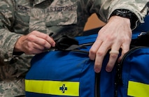 An Airman with the 5th Medical Operations Squadron unzips a medical first aid bag at Minot Air Force Base, N.D., Dec. 1, 2016. The ambulance services department is responsible for supplying critical support such as administering immunizations and assisting during aeromedical evacuations. (U.S. Air Force photo/Airman 1st Class Jonathan McElderry)