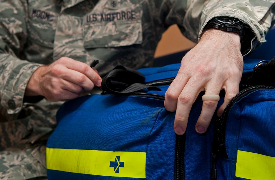 An Airman with the 5th Medical Operations Squadron unzips a medical first aid bag at Minot Air Force Base, N.D., Dec. 1, 2016. The ambulance services department is responsible for supplying critical support such as administering immunizations and assisting during aeromedical evacuations. (U.S. Air Force photo/Airman 1st Class Jonathan McElderry)