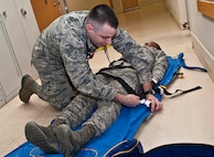 (From left) Senior Airman Robert Moon, 5th Medical Operations Squadron aerospace medical technician, a simulated patient to a sand vacuum splint at Minot Air Force Base, N.D., Dec. 1, 2016. The sand vacuum splint helps relieve pressure from a patient’s injured area and also provides comfort by conforming to an individual’s body. (U.S. Air Force photo/Airman 1st Class Jonathan McElderry)