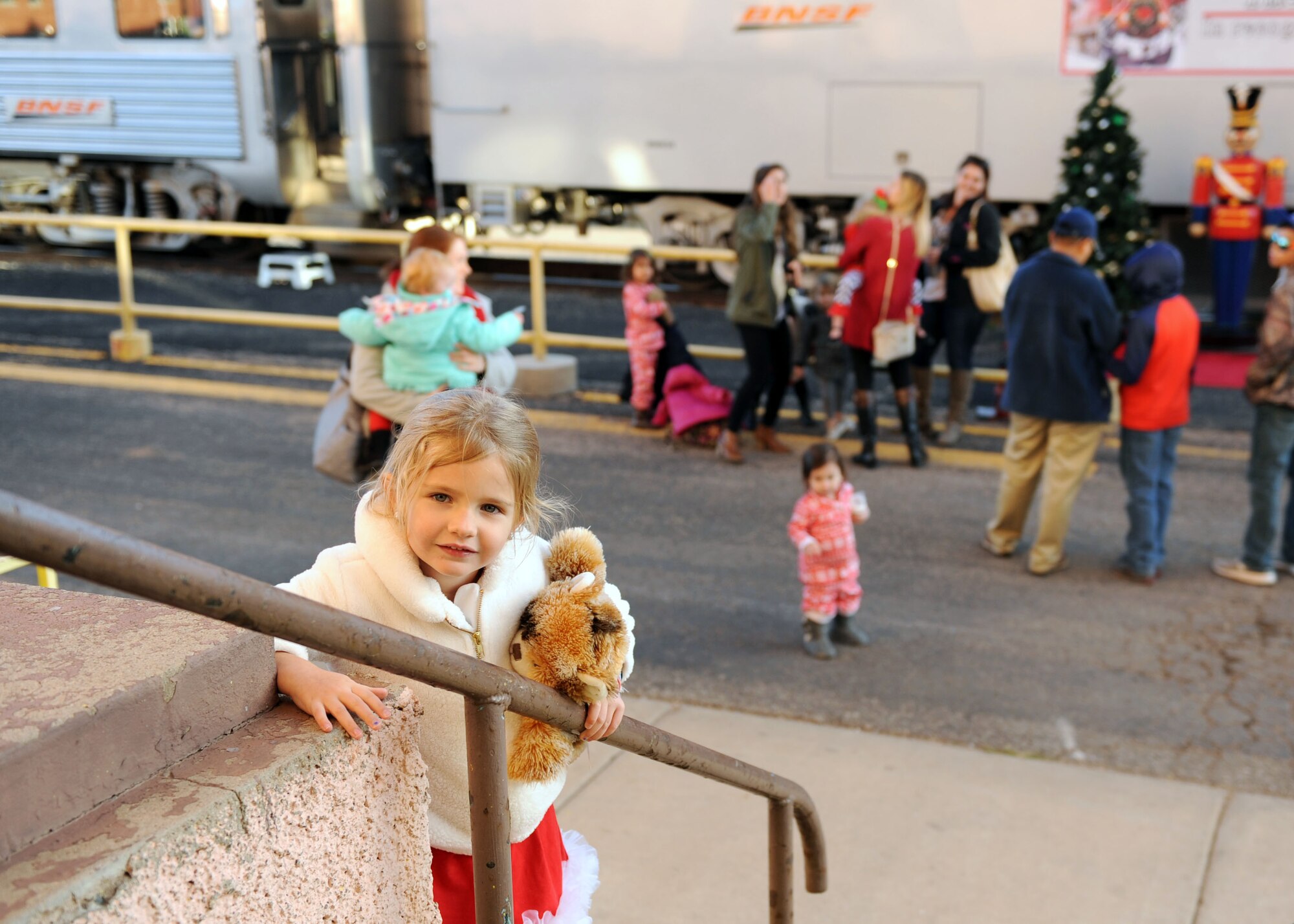 A dependent from Cannon Air Force Base, N.M., waits to board the Holiday Express, Dec. 1, 2016, at a railyard in downtown Clovis, N.M. For nine consecutive years, the BNSF Railway has invited service members and their loved ones aboard the Holiday Express to enjoy milk, cookies, and a visit from Santa Claus to show their appreciation. (U.S. Air Force photo by Staff Sgt. Whitney Amstutz/Released)  