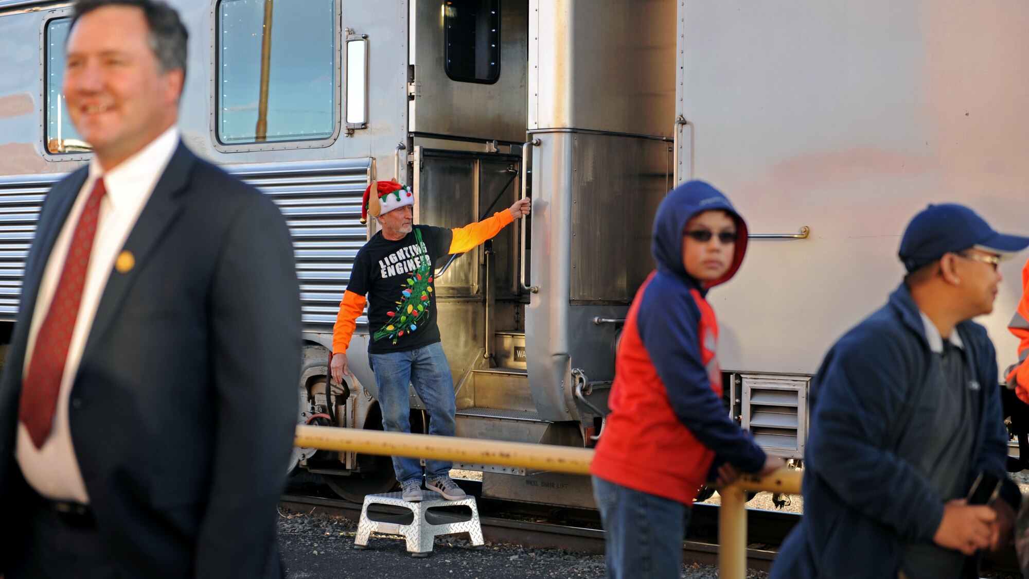 Dressed as an elf, a BNSF Railway employee waits to welcome passengers aboard the Holiday Express, Dec. 1, 2016, at a railyard in downtown Clovis, N.M. For nine consecutive years, the BNSF Railway has invited service members and their loved ones aboard the Holiday Express to enjoy milk, cookies, and a visit from Santa Claus to show their appreciation. (U.S. Air Force photo by Staff Sgt. Whitney Amstutz/Released)  
